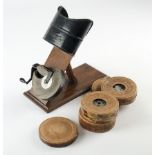 A Kinora Film Reel Viewer, on hinged oak plinth, G, one lens missing, cowl repainted, with five