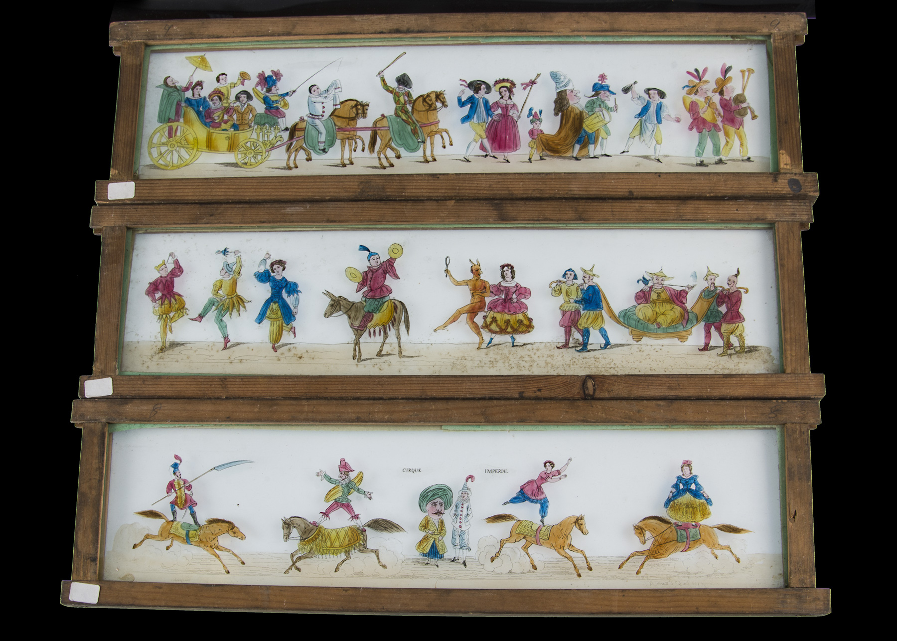 Eleven Early Mahogany-Framed Hand-Coloured Long Magic Lantern Slides, each 390mm x 105mm, various