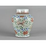 An Chinese porcelain Wucai vase, of baluster shape, decorated with Buddhistic lion dogs, against a