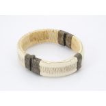 A late 19th century African ivory and silver mounted bangle