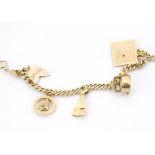 A gold charm bracelet, 9ct or 14ct gold flattened curb link chain supporting five 9ct and 14ct