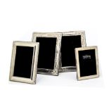 A group of four modern silver photograph frames, including a pair with embossed edging,