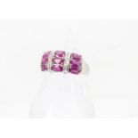 A modern 14ct white gold and ruby dress ring, the tablet set with nine oval synthetic rubies, 4.5g