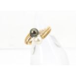 A French gold and pearl torsion ring, having a white and a black pearl to each terminal, strike