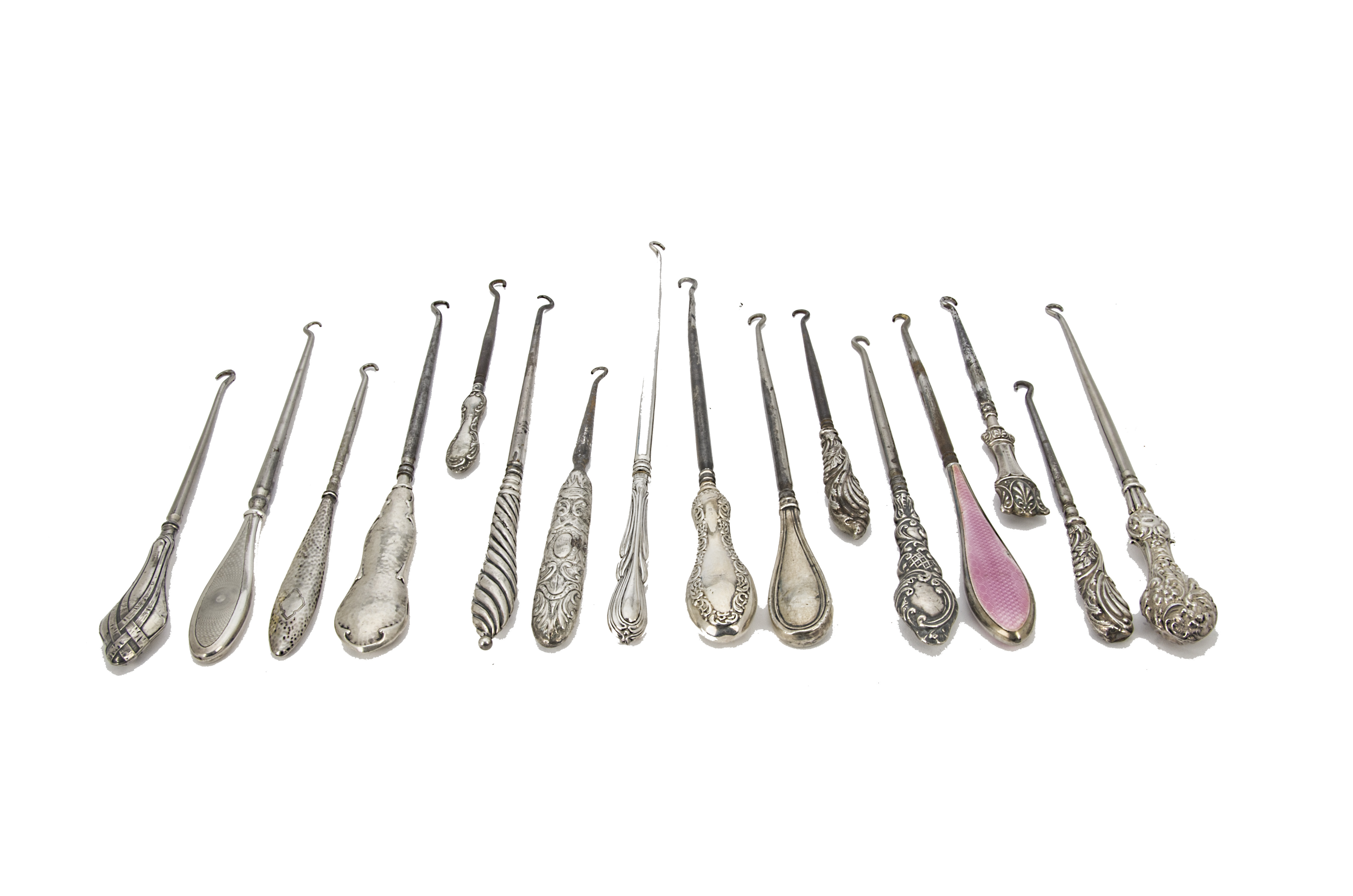 A collection of 16 Victorian and later silver handled button hooks, including one with pink