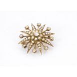 An early 20th century gold seed pearl and diamond star brooch, centred with an old cut diamond and