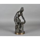 A late 19th Century French bronze sculpture, of a classical woman, nude to the waist, lifting a bowl