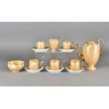 An Art Deco coffee set in orange lustre with orange and cream lustre triangular decoration,