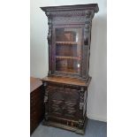 A Victorian carved oak display cabinet, raised glazed panel door, waist drawer, base with carved