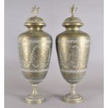 A pair of Indian brass urns and covers, etched figurative and scroll decoration, finials in the form