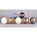 A set of seven ostrich eggs, five hand-painted with floral decoration in a variety of colours,