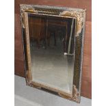 A reproduction gilt and ebonised bevelled glass wall mirror, 50 cm x 76 cm
