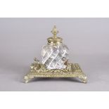 A Victorian heavy glass and brass inkwell, square base with central glass well, in gothic style on