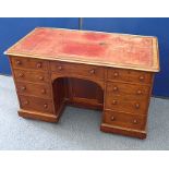 A Victorian mahogany knee hole desk, tooled leather, above nine drawers, turned pulls, casters,