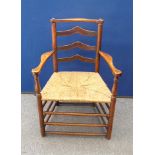 A 19th Century ash and elm ladderback cottage armchair, rush seat, stretchered supports