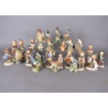 A collection of Goebel and Hummel figurines, together with a collection of bird figures