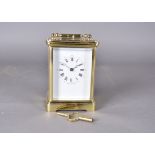 A modern brass repeater carriage clock, white face, Roman numerals, 15 cm high