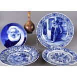 Two 20th Century Dutch Delft floral painted chargers, together with a painted charger depicting a