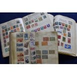 A collection of vintage stamps, in four small school boy albums and loose together with some FDCs