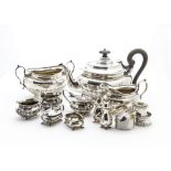 An Edwardian silver three piece cruet set, together with a George V silver four piece cruet set, a