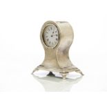 An early George V period silver mantle clock by William Comyns, rectangular spreading base with four