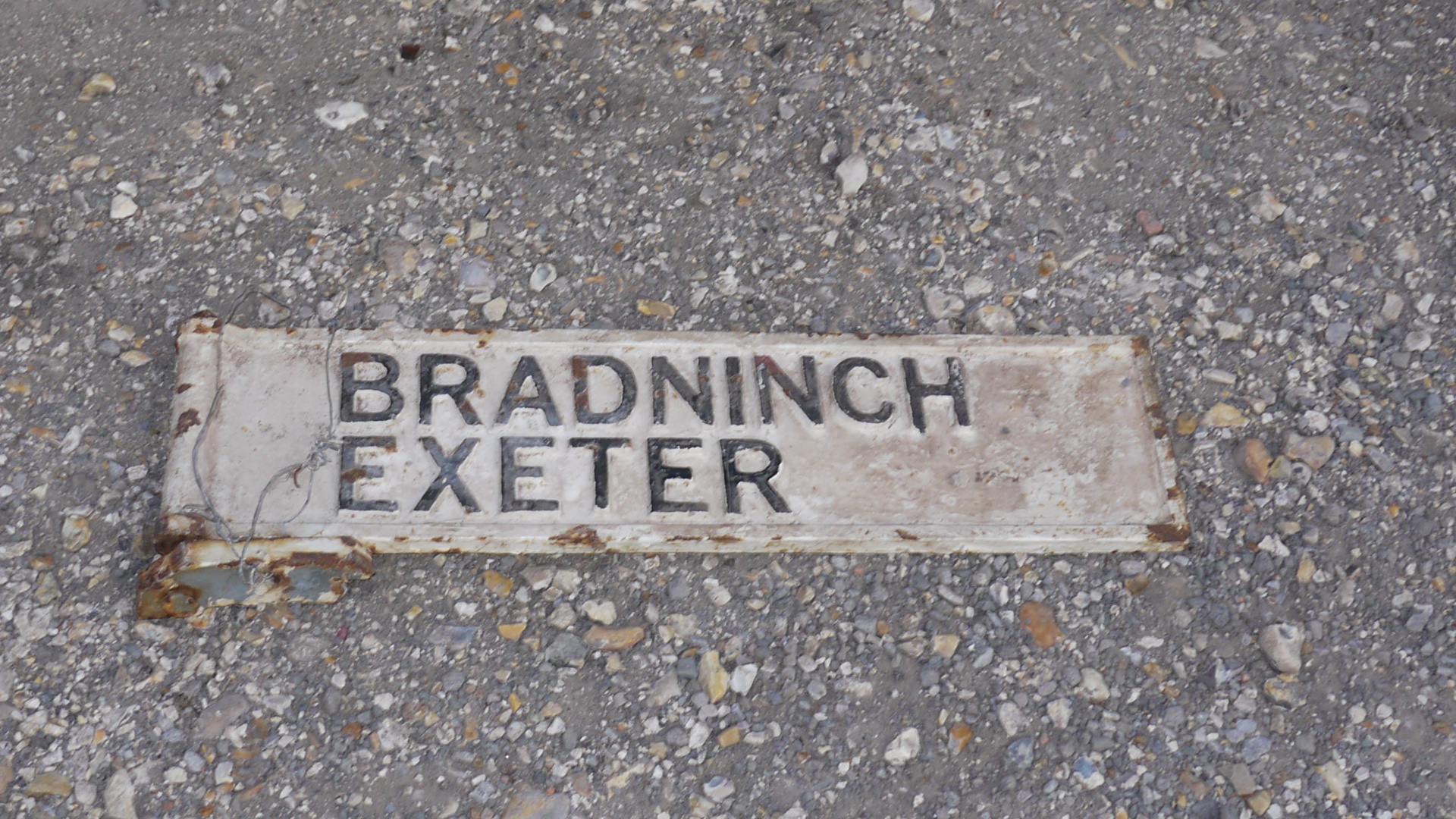 Bradninch and Exeter Sign, An original cast iron post mounted double sided, direction sign, black on