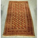 A Middle-Eastern Caucasian woolen rug, geometric guls on red field, geometric border, 208 cm x 117