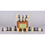A Staunton set of chess men with weighted bases, the rooks and knights marked with red crown, the