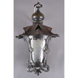 An arts and crafts copper lantern, the shaped top supporting a pierced and glazed lantern, some