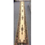 A Middle-Eastern woolen runner, five pole medallions on ivory field, indigo scroll patterned border,