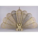 A brass peacock fan spark guard with griffin decoration, 63 cm high together with a gilt gesso