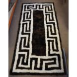 A modern Greek goat fleece rug with Greek key decoration in chocolate brown and cream, 195 cm x 95