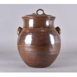 A large stoneware hand thrown studio twin handled pot and cover with an all over iron glaze, small