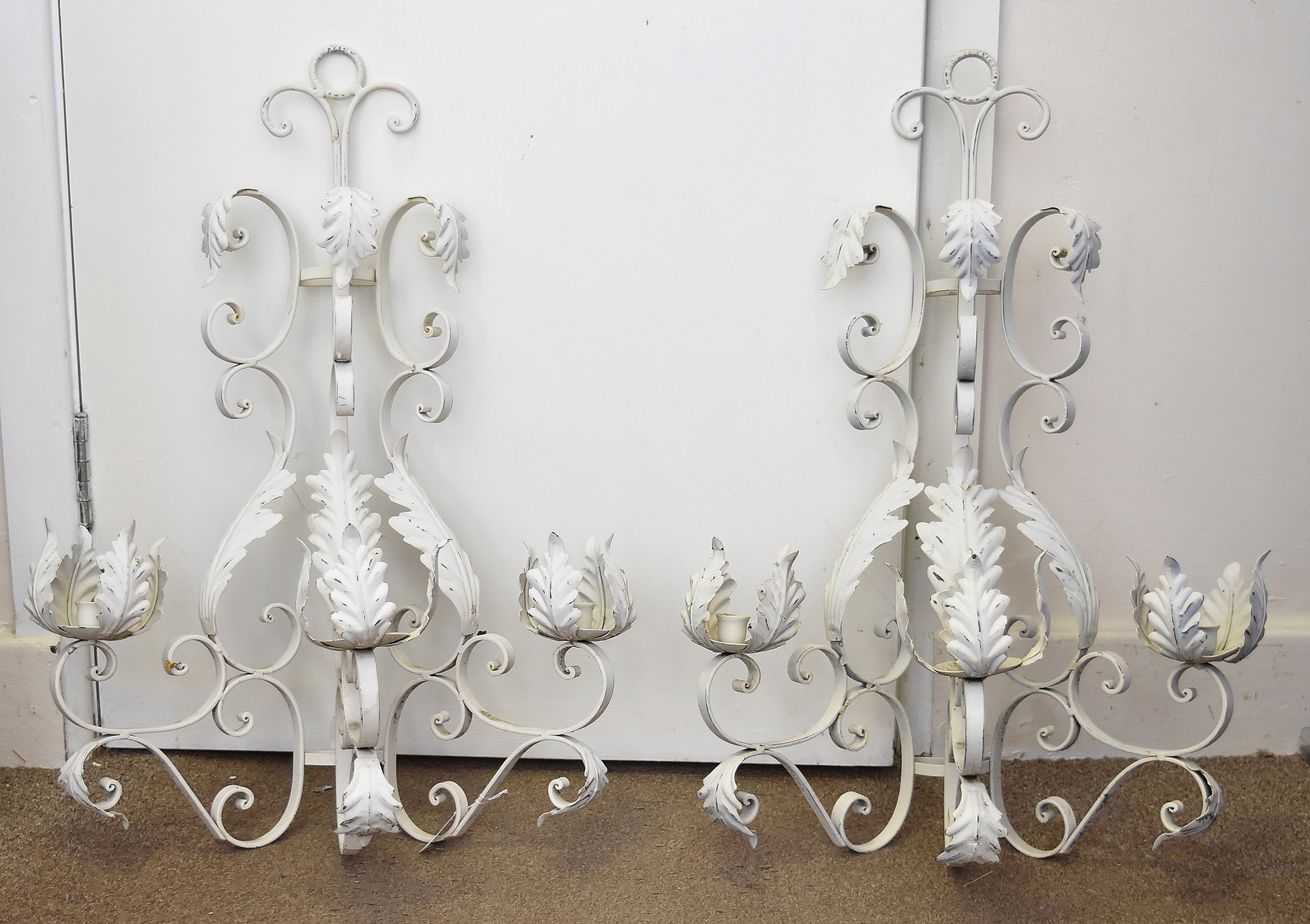 A pair of wrought iron white painted foliate wall hanging candle sconces, approx 75 cm