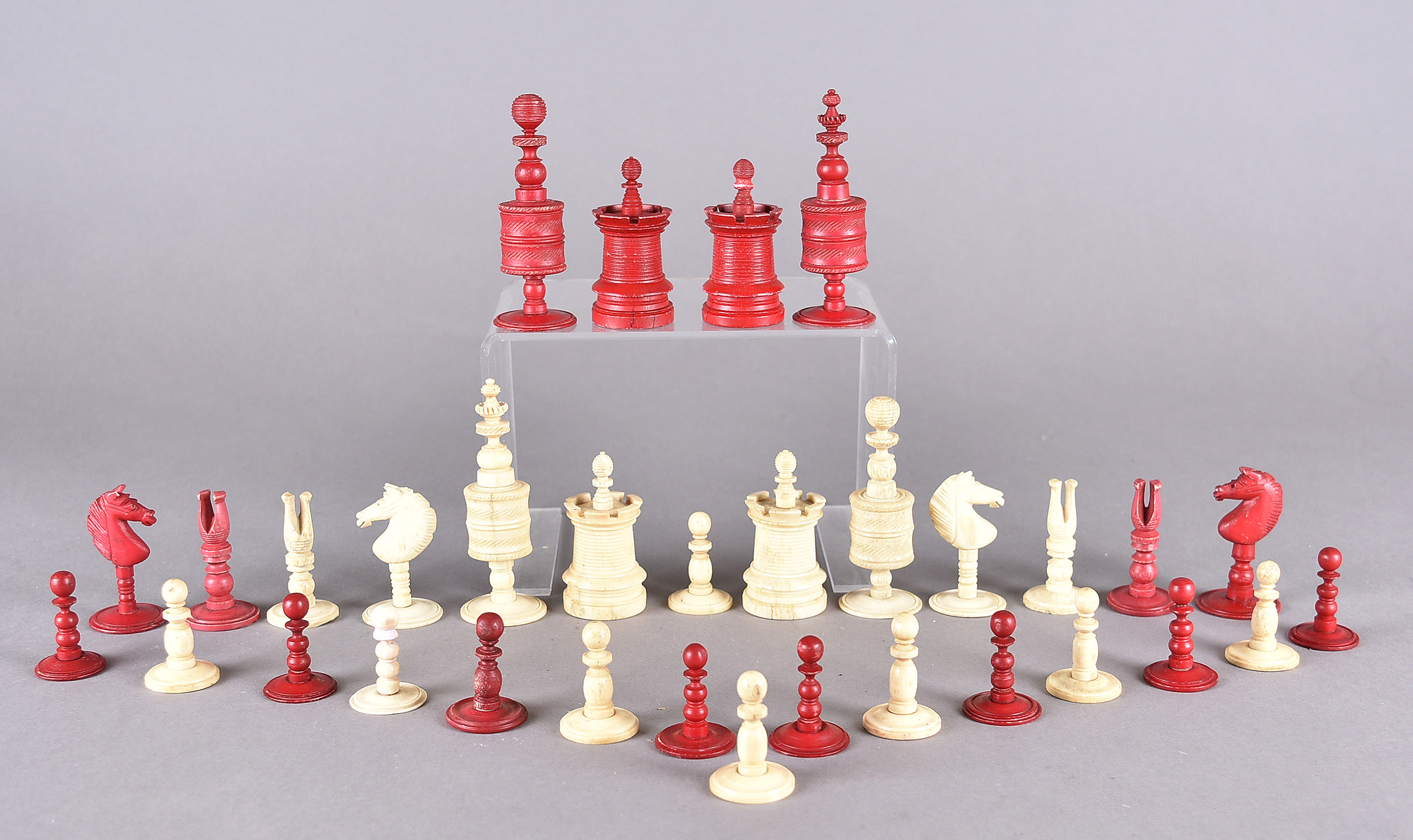 A 19th Century bone set of chess men in natural and stained red, all on turned circular bases (32)