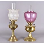 Two brass oil lamps one with opaque glass shade (af) the other with cranberry shade