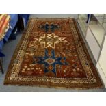 A vintage Caucasian woolen rug, three brown, blue and ivory cruciform medallions on brown field,