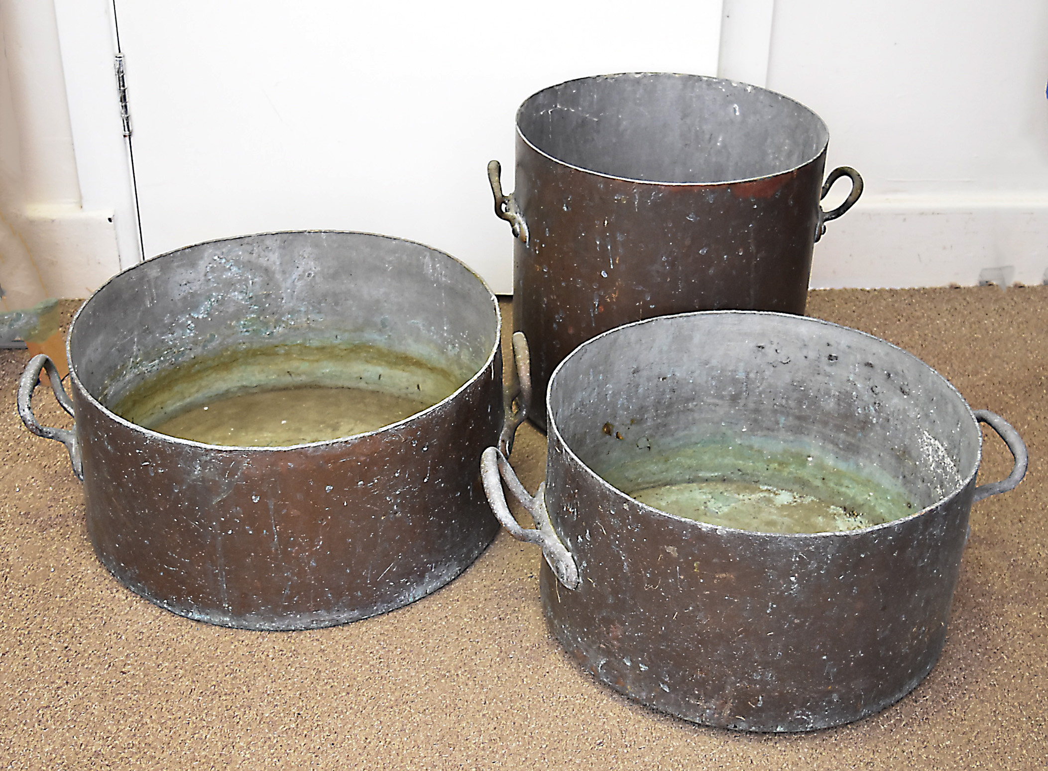 Three large copper twin handled preserve pans, largest 44 cm diameter, 40 cm diameter and 35 cm