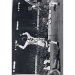 MIKE ENGLAND - TOTTENHAM Col 12” x 8” photo, showing Tottenham’s Mike England running away in