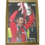 ERIC CANTONA AUTOGRAPH A 13" X 9" framed and glazed signed colour photograph of Cantona lifting