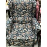 A wing back open arm chair with floral design on c