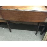 A mahogany drop leaf table on ring turned legs