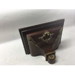 A large mahogany wall bracket with gilded ornate m