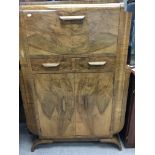 An Art Deco walnut cocktail cabinet with a hinged