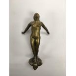 A vintage white metal car mascot of a nude female