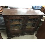 An Old Charm bookcase with lead light glass doors.