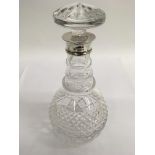 A cut glass decanter with silver mount