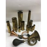 A box of military brass shell cases plus a bugle and horn