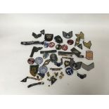 A bag containing a large amount of military cloth badges and some smaller pin badges, made up of