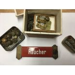 A box containing a collection of military buttons and a German smoking sign.